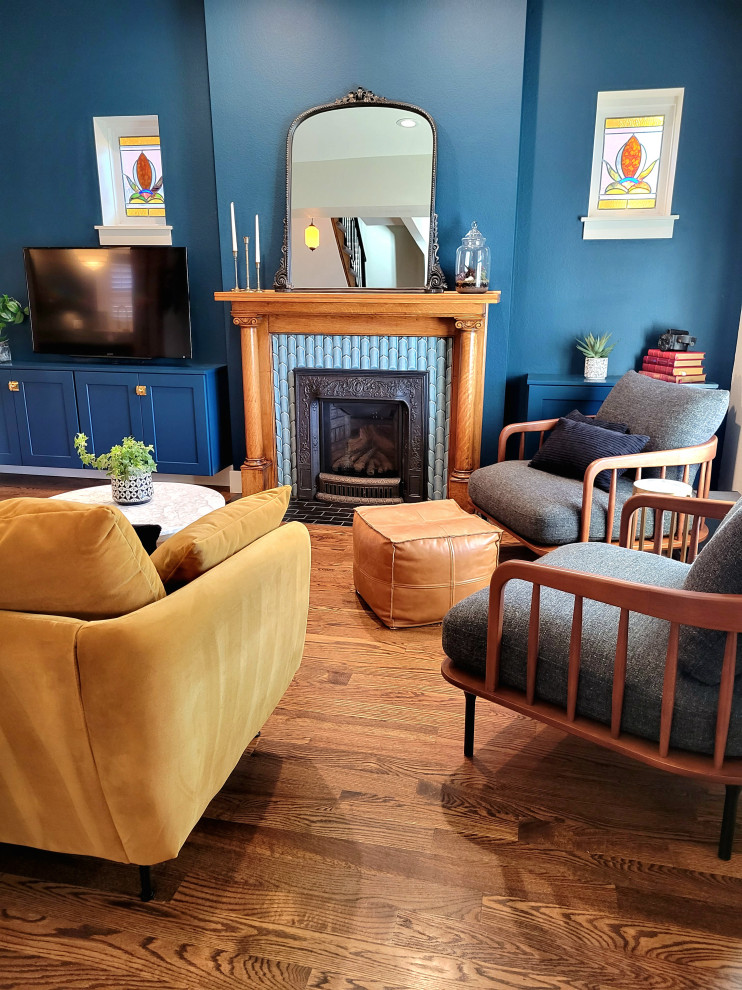 デンバーにある高級な中くらいなエクレクティックスタイルのおしゃれなファミリールーム (青い壁、無垢フローリング、標準型暖炉、タイルの暖炉まわり) の写真