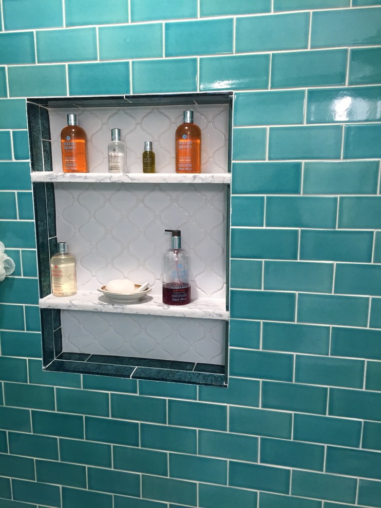 Photo of a small eclectic 3/4 bathroom in Newark with recessed-panel cabinets, white cabinets, an alcove tub, a two-piece toilet, green tile, ceramic tile, white walls, porcelain floors, an undermount sink, engineered quartz benchtops, grey floor and a sliding shower screen.