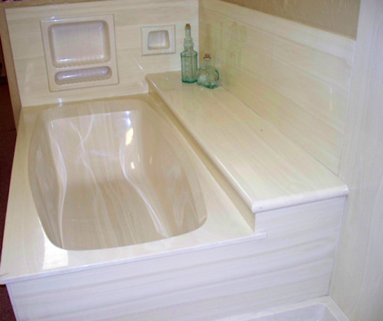Example of a bathroom design in Phoenix with limestone countertops, an undermount tub and white walls