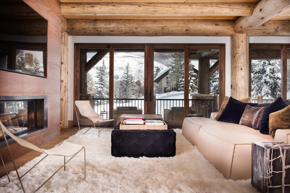 Vail Ski Haus - Mid-sized mountain style open concept medium tone wood floor and brown floor family room photo in Denver with white walls, a ribbon fireplace, a wood fireplace surround and a wall-mounted tv