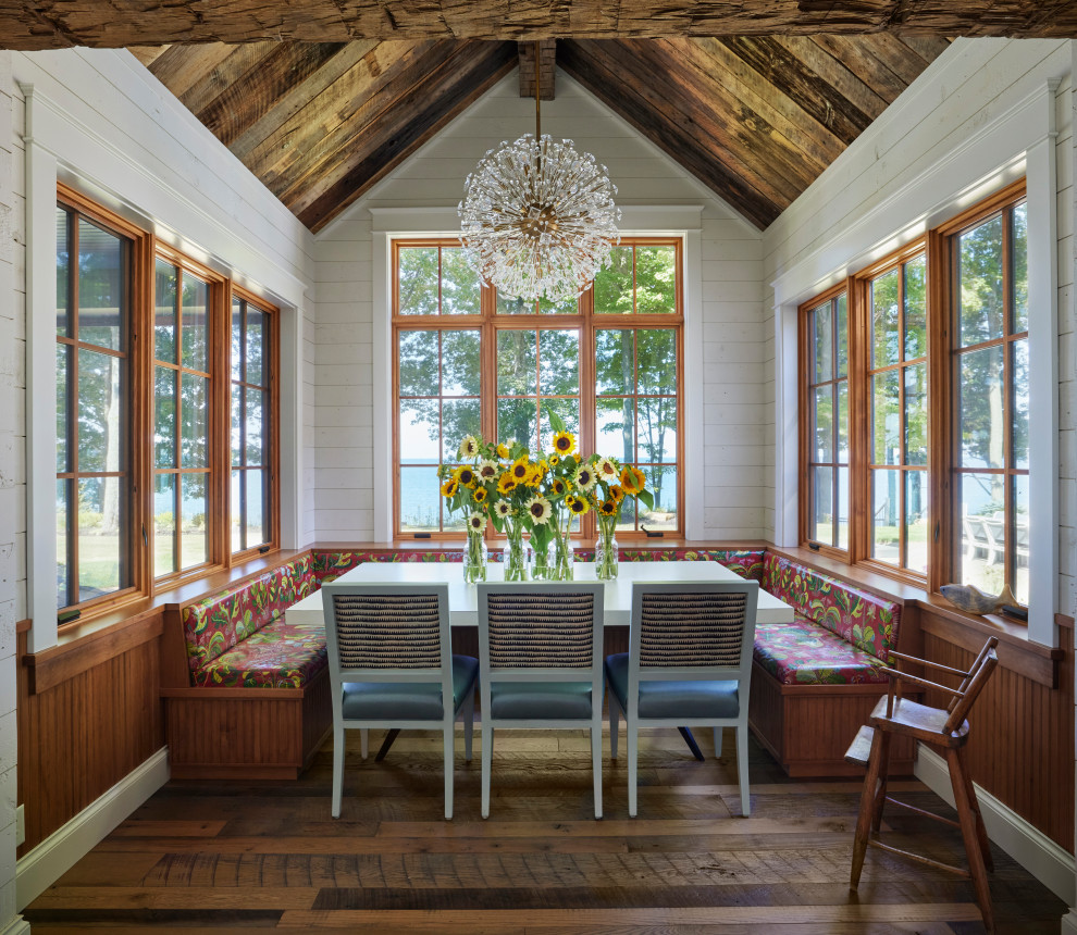 Inspiration pour une salle à manger chalet avec une banquette d'angle, un mur blanc, parquet foncé, un sol multicolore, un plafond voûté et du lambris de bois.
