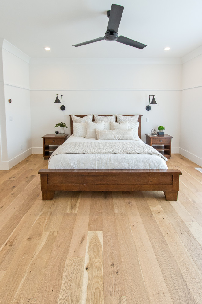 Klassisches Schlafzimmer mit weißer Wandfarbe, hellem Holzboden und braunem Boden in Sonstige