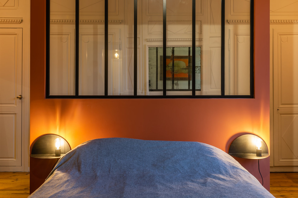 パリにある広いモダンスタイルのおしゃれな主寝室 (赤い壁、無垢フローリング、暖炉なし、茶色い床)