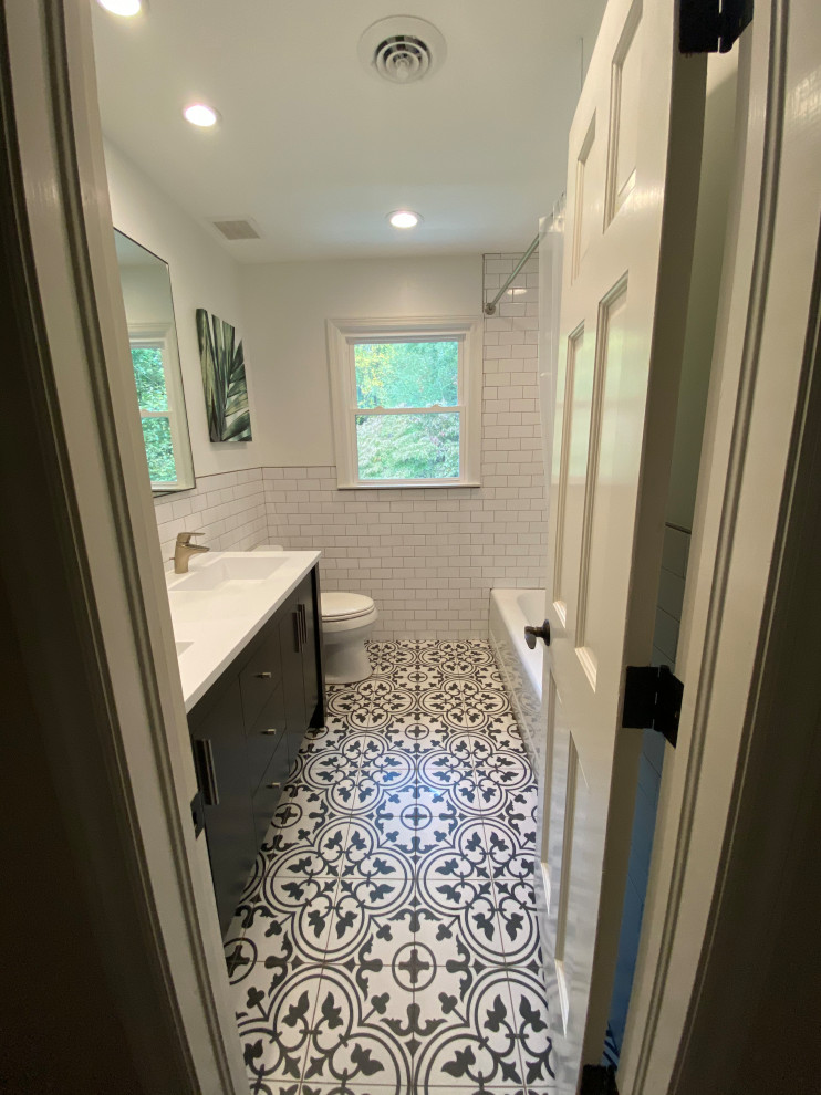 Photo of a small transitional kids bathroom in Atlanta with furniture-like cabinets, a one-piece toilet, ceramic floors, an undermount sink, marble benchtops, white floor, white benchtops, a double vanity, a freestanding vanity, decorative wall panelling, dark wood cabinets, an alcove tub, a shower/bathtub combo, black and white tile, subway tile, white walls and a shower curtain.