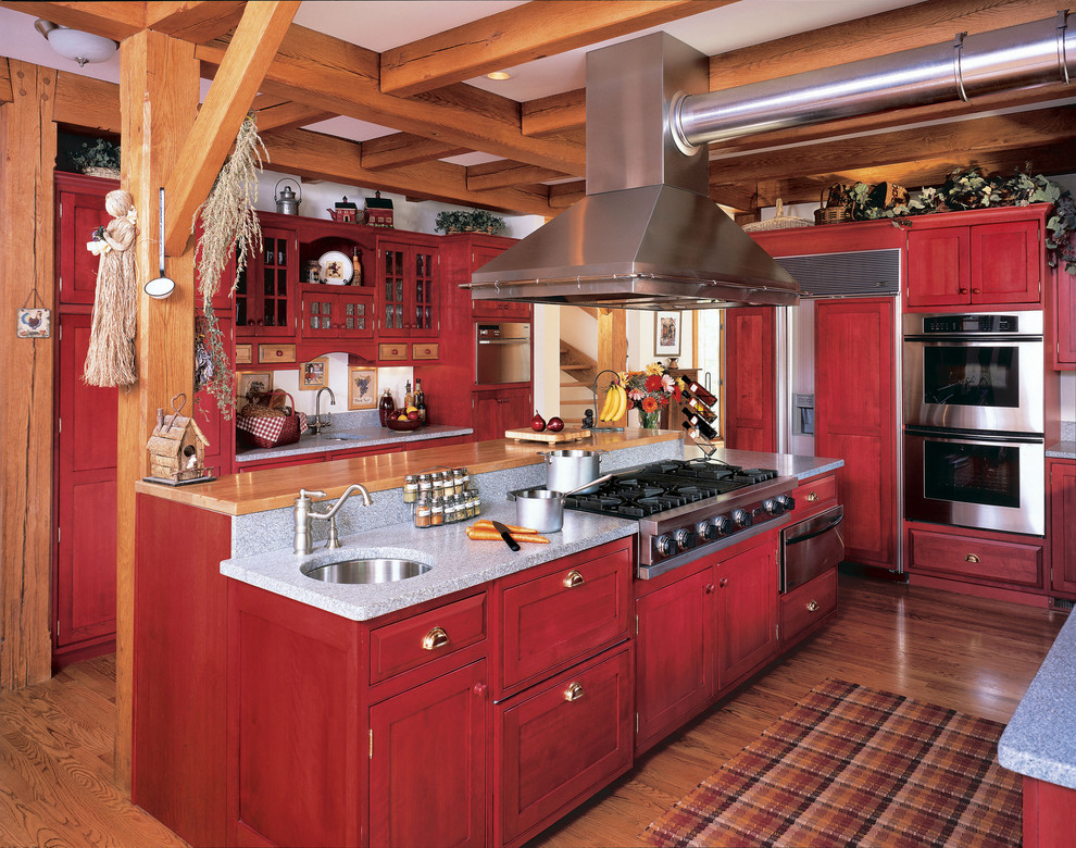 This is an example of a country separate kitchen in Other with shaker cabinets, panelled appliances, an undermount sink and red cabinets.