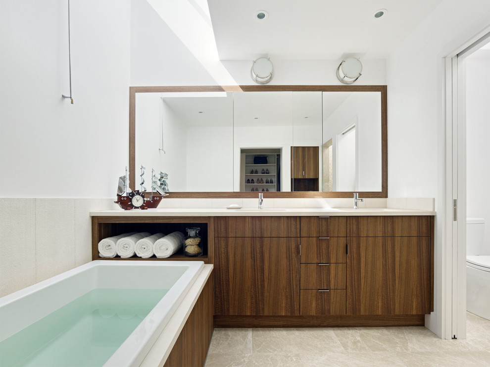 Photo of a large modern master bathroom in San Francisco with flat-panel cabinets, dark wood cabinets, a drop-in tub, beige tile and white walls.