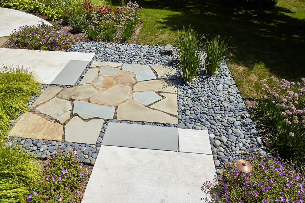 Mid-sized midcentury courtyard full sun xeriscape in Milwaukee with a garden path and natural stone pavers.