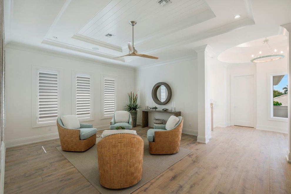 Design ideas for a large beach style hallway in Miami with white walls and light hardwood floors.