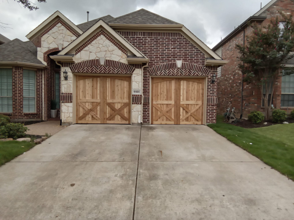 This is an example of a large traditional attached two-car garage in Dallas.
