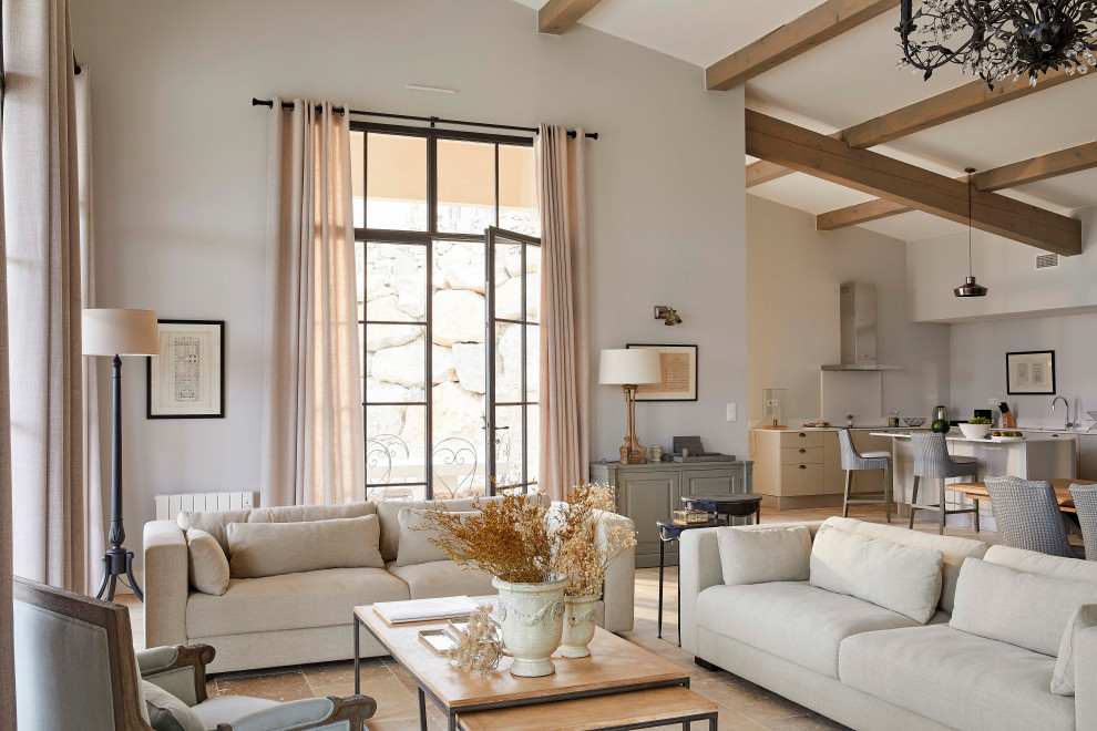 Imagen de salón abierto tradicional renovado grande con paredes beige, suelo de travertino, suelo beige y vigas vistas