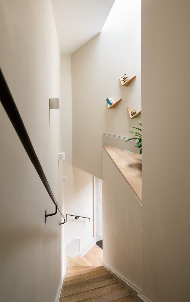 Inspiration for a scandinavian wood staircase in London with metal railing.