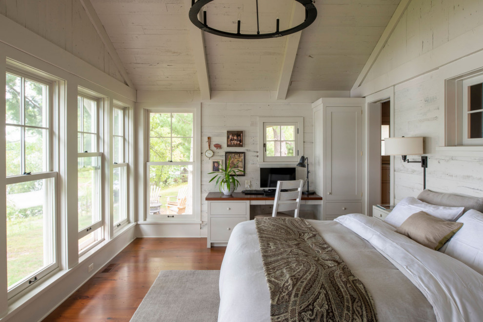 Mittelgroßes Maritimes Hauptschlafzimmer mit weißer Wandfarbe, braunem Holzboden, gewölbter Decke und Holzwänden in Minneapolis