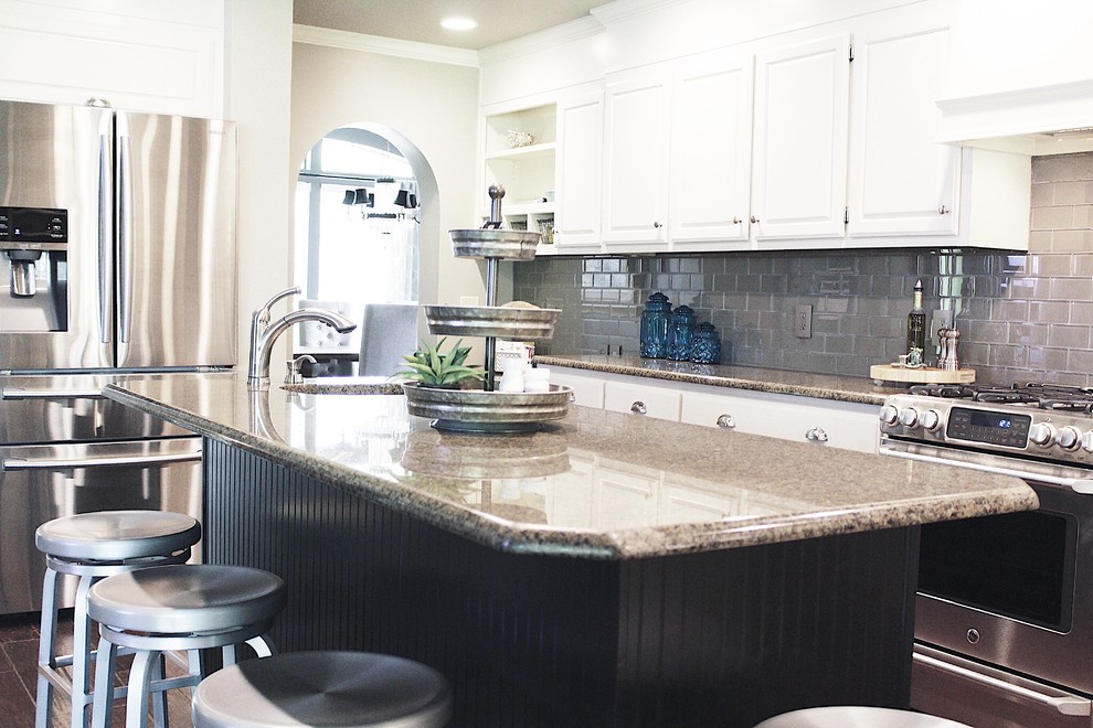 Enclosed kitchen - mid-sized transitional l-shaped dark wood floor and brown floor enclosed kitchen idea with an undermount sink, raised-panel cabinets, white cabinets, granite countertops, gray backsplash, glass tile backsplash, stainless steel appliances and an island