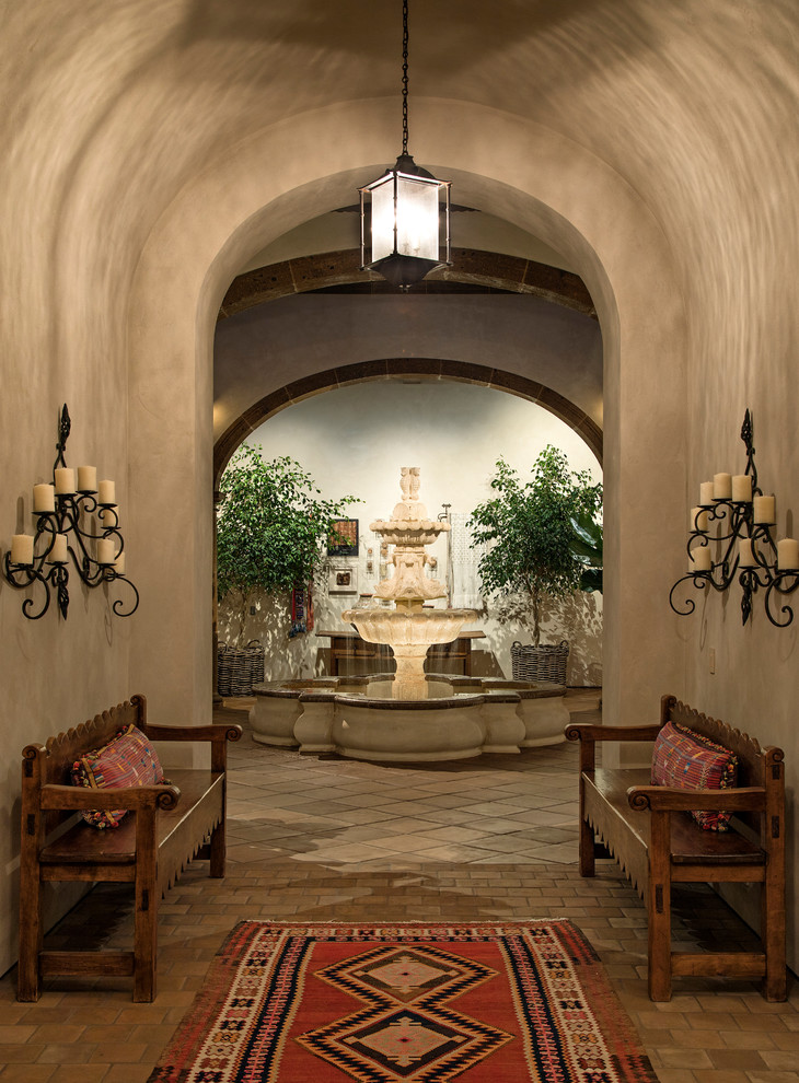 This is an example of a large mediterranean entryway in Santa Barbara with a double front door and a dark wood front door.