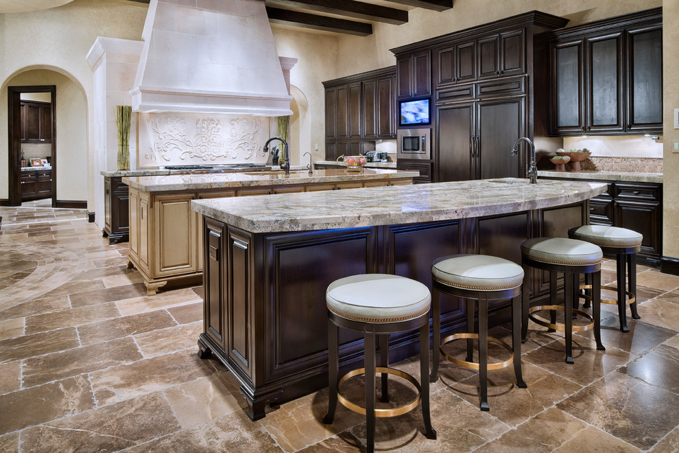This is an example of a mediterranean eat-in kitchen in Houston with dark wood cabinets, multi-coloured splashback and multiple islands.