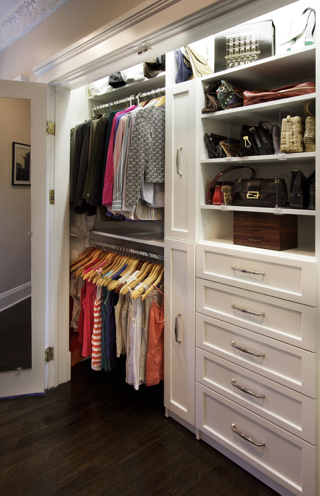 Photo of a small transitional women's built-in wardrobe in New York with shaker cabinets, white cabinets and dark hardwood floors.