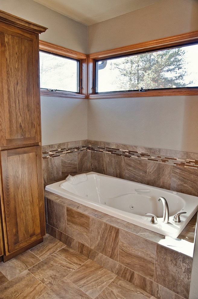 This is an example of a large arts and crafts master bathroom in Other with recessed-panel cabinets, brown cabinets, a drop-in tub, an alcove shower, a two-piece toilet, brown tile, ceramic tile, brown walls, ceramic floors, a vessel sink, granite benchtops, brown floor and an open shower.