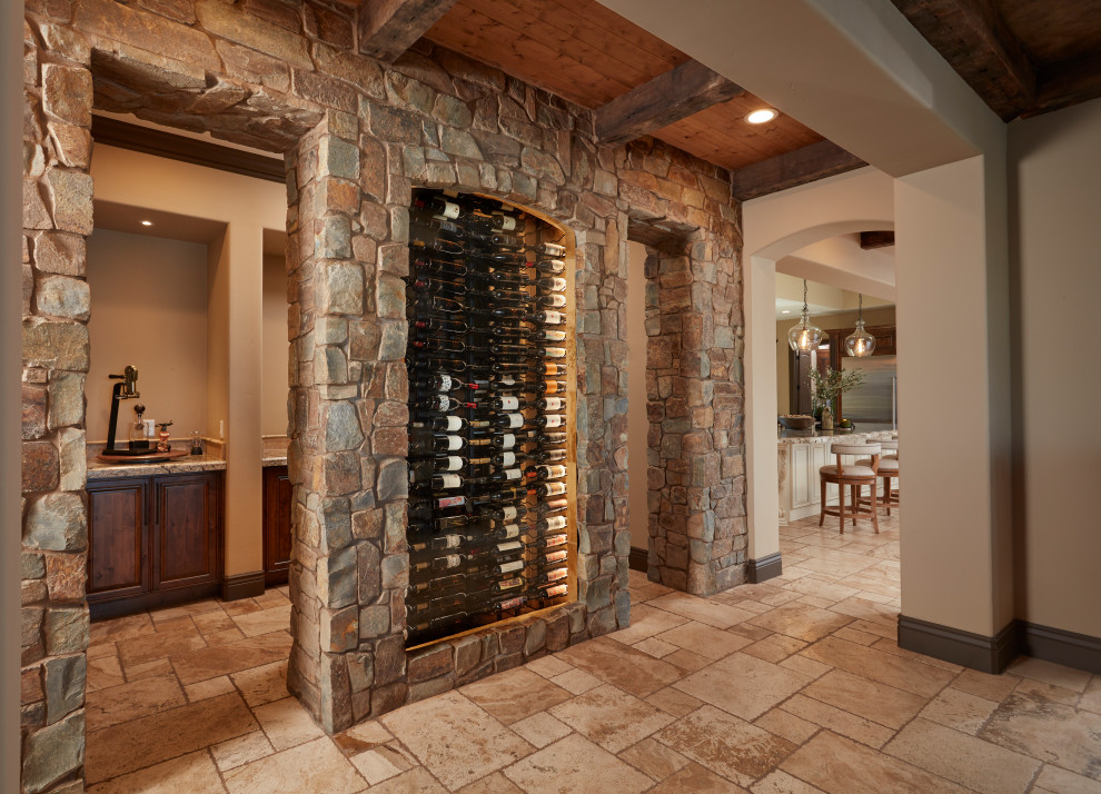 This is an example of a medium sized mediterranean wine cellar in San Francisco with limestone flooring and storage racks.