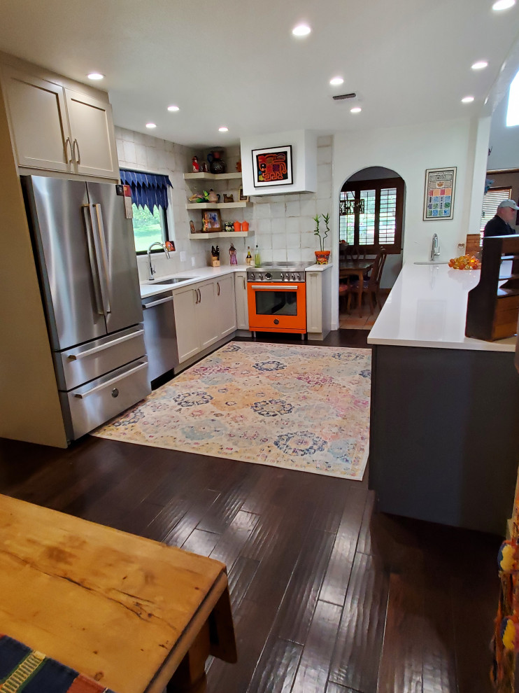 Example of a mid-sized southwest galley medium tone wood floor and brown floor eat-in kitchen design in Austin with an undermount sink, shaker cabinets, gray cabinets, quartz countertops, gray backsplash, ceramic backsplash, colored appliances, no island and white countertops