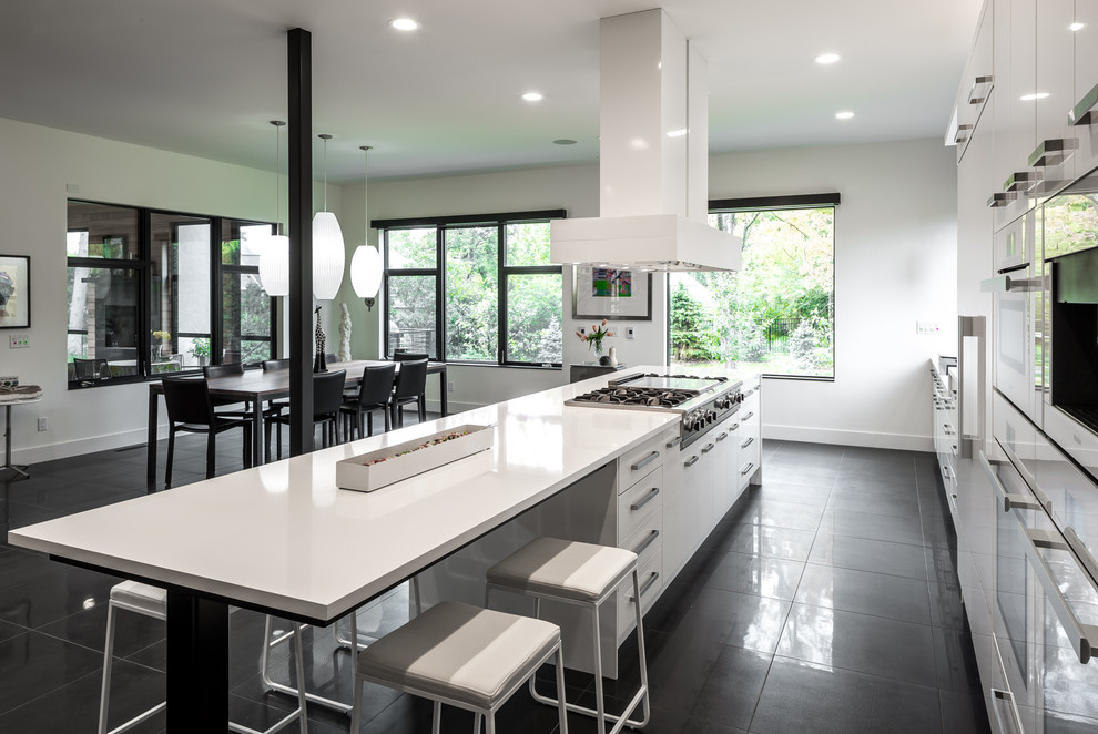 Photo of an expansive contemporary galley open plan kitchen in Minneapolis with with island, a single-bowl sink, flat-panel cabinets, white cabinets, quartz benchtops, white splashback, white appliances and porcelain floors.
