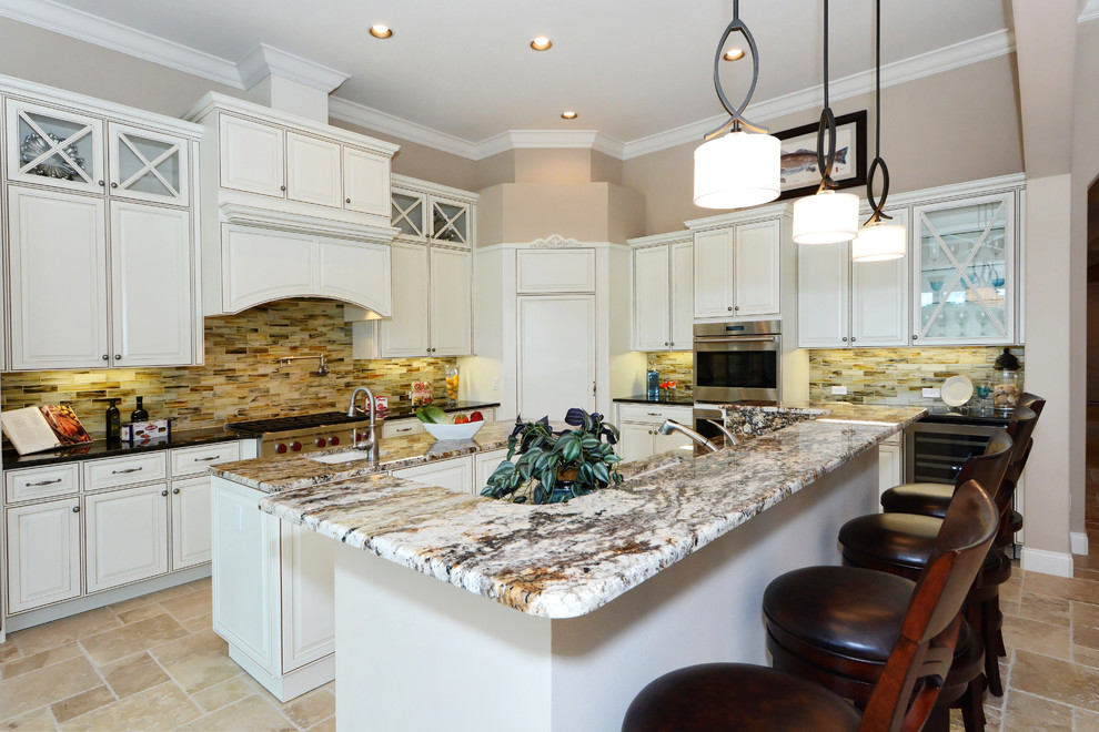 Photo of a traditional open plan kitchen in Tampa with an undermount sink, granite benchtops, stainless steel appliances, travertine floors and multiple islands.