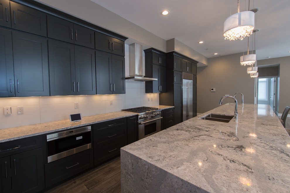 Large transitional galley open concept kitchen photo in Grand Rapids with gray cabinets, stainless steel appliances, an island, quartz countertops, an undermount sink and recessed-panel cabinets
