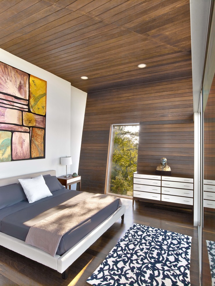 Contemporary bedroom in New York with brown walls, dark hardwood floors and brown floor.