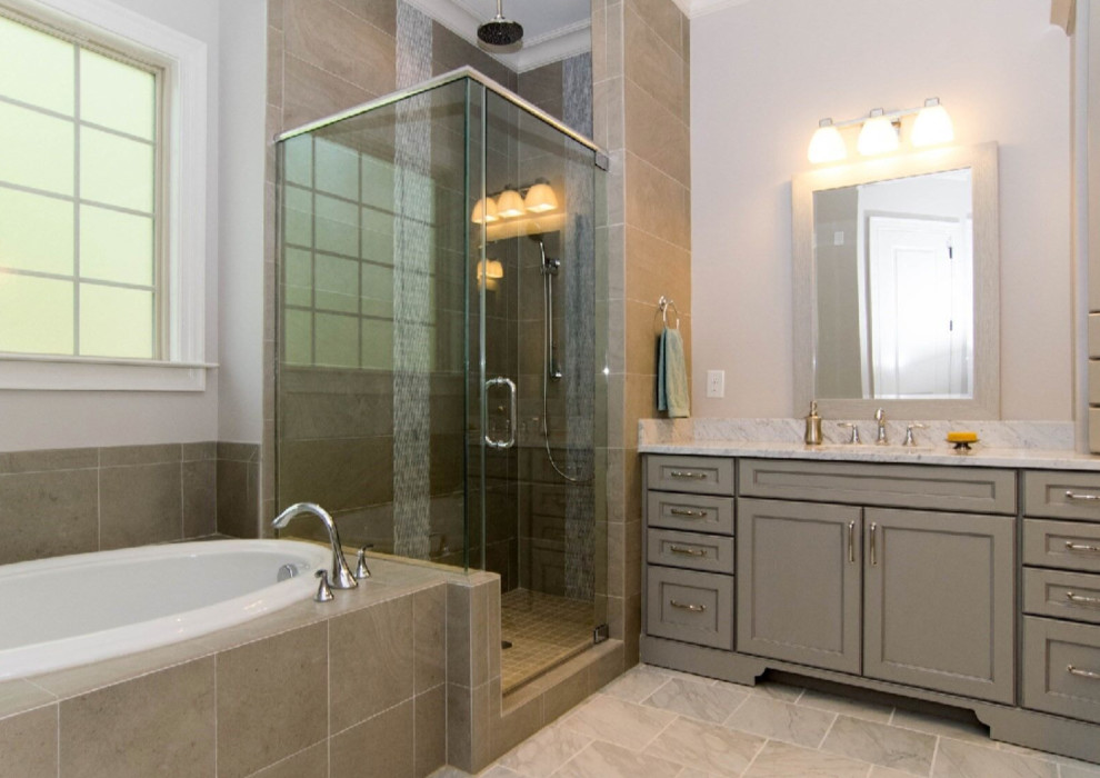 Large transitional master bathroom in Raleigh with shaker cabinets, grey cabinets, a drop-in tub, a corner shower, a two-piece toilet, gray tile, porcelain tile, grey walls, slate floors, an undermount sink, marble benchtops, grey floor and a hinged shower door.