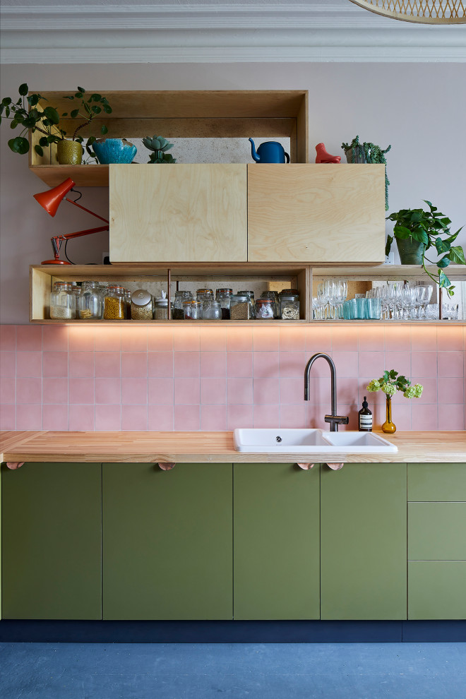 This is an example of a mid-sized modern l-shaped eat-in kitchen in London with flat-panel cabinets, green cabinets and wood benchtops.