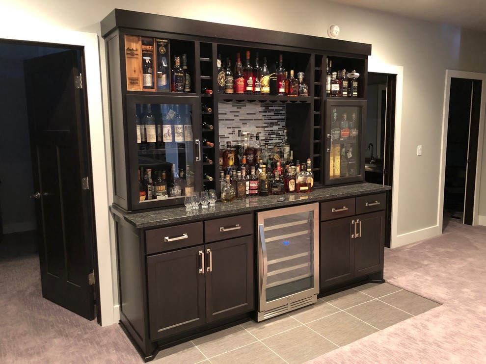Design ideas for a mid-sized traditional single-wall home bar in Other with no sink, dark wood cabinets, granite benchtops, multi-coloured splashback, glass sheet splashback, vinyl floors, multi-coloured floor and multi-coloured benchtop.