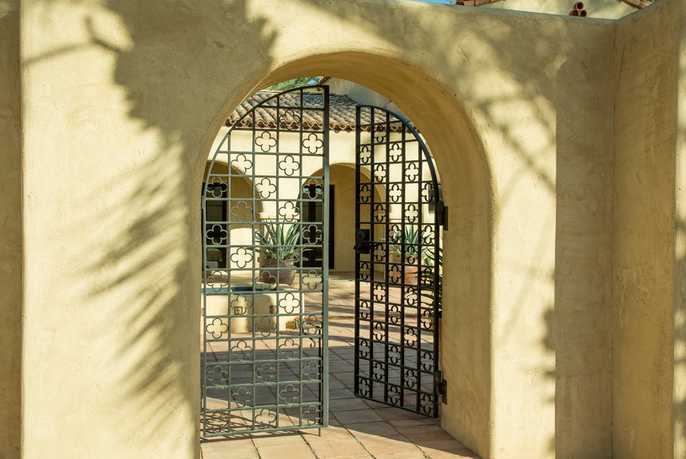 Expansive two-storey adobe beige house exterior in Phoenix with a gable roof and a tile roof.