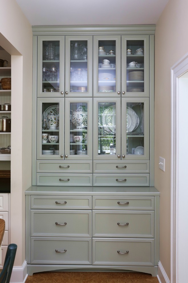 Traditional kitchen in Raleigh with glass-front cabinets, green cabinets and cork floors.