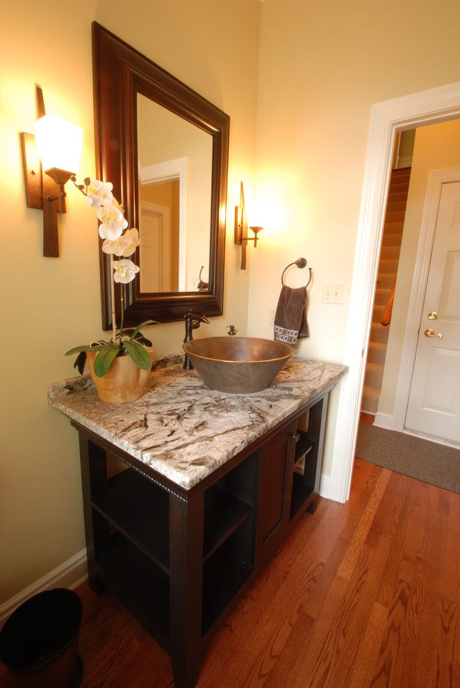 Bathroom - mid-sized transitional 3/4 medium tone wood floor bathroom idea with a vessel sink, recessed-panel cabinets, dark wood cabinets, granite countertops and yellow walls
