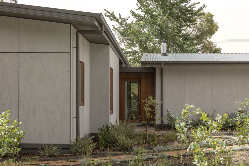 Small contemporary one-storey grey house exterior in Canberra - Queanbeyan with a flat roof and a metal roof.
