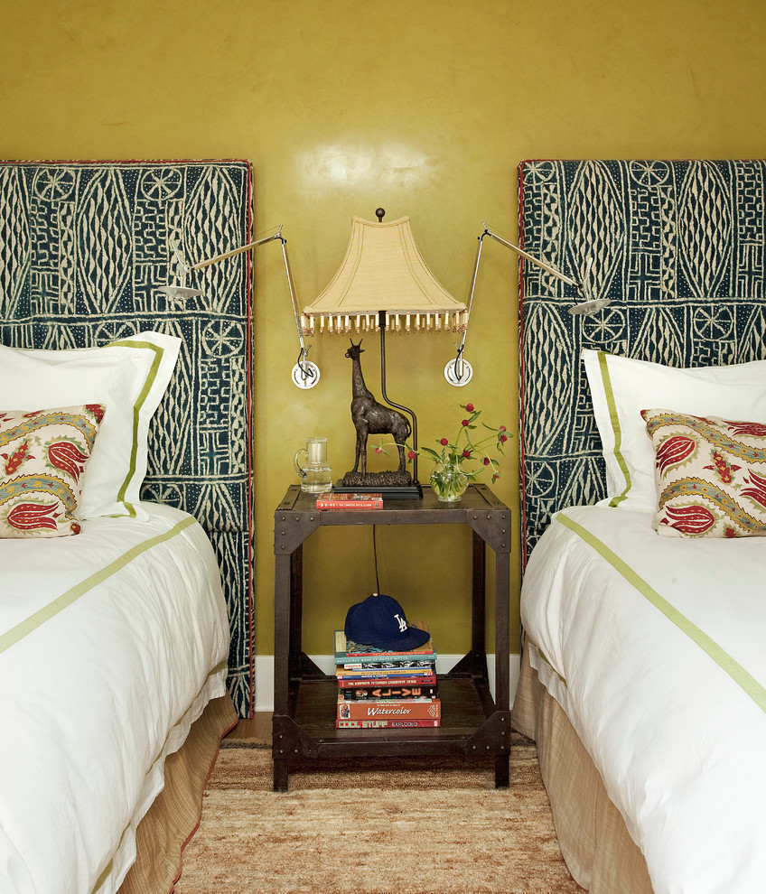 This is an example of an eclectic guest bedroom in New York with yellow walls.