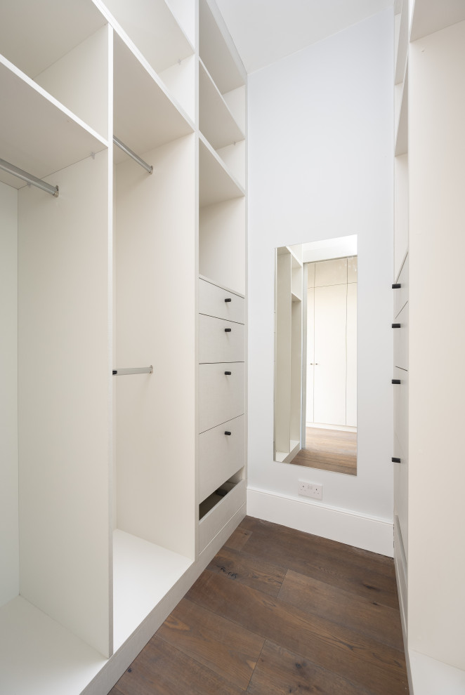 Design ideas for a small contemporary gender-neutral storage and wardrobe in London with flat-panel cabinets, grey cabinets and brown floor.
