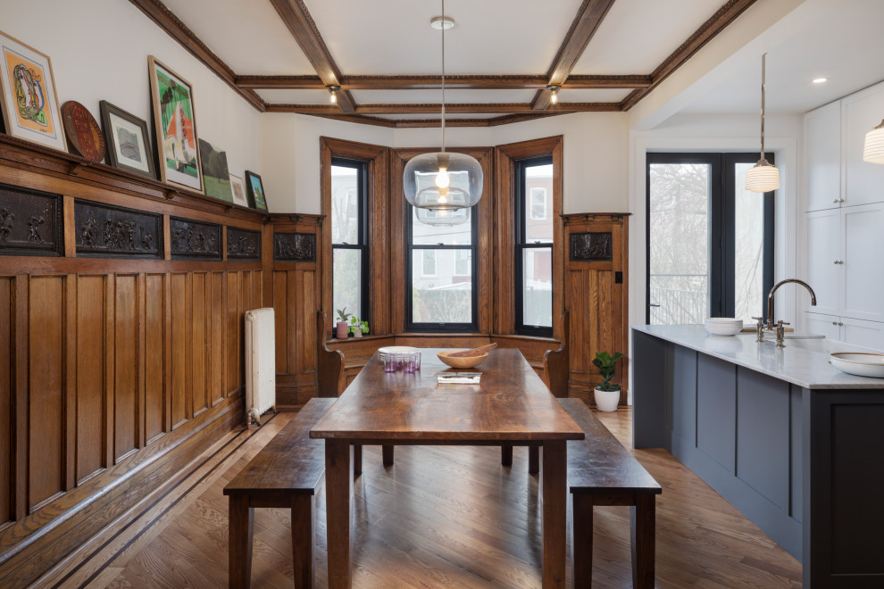 Photo of a transitional dining room in New York with white walls, medium hardwood floors, brown floor, exposed beam and decorative wall panelling.