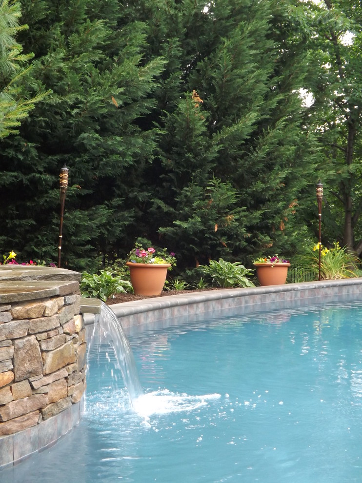 Design ideas for a large traditional backyard kidney-shaped pool in Philadelphia with a hot tub and concrete pavers.