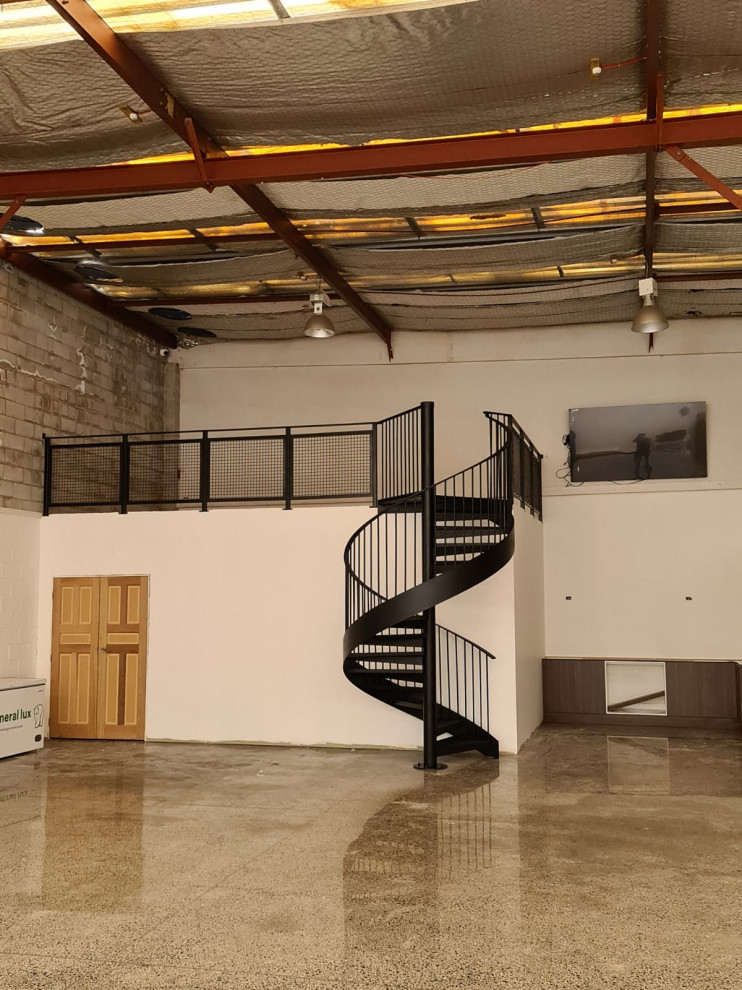 Example of a mid-sized urban metal spiral open and metal railing staircase design in Auckland