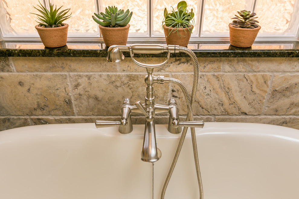 Inspiration for a large transitional master beige tile and stone tile travertine floor freestanding bathtub remodel in Austin with raised-panel cabinets, gray cabinets, a two-piece toilet, gray walls, an undermount sink and granite countertops