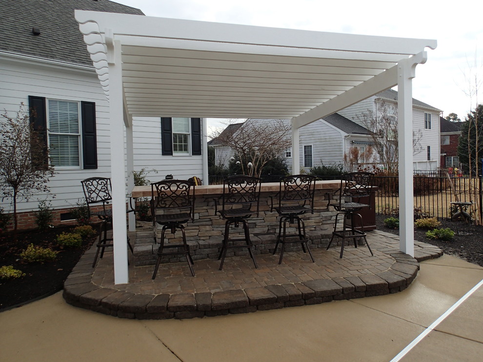 Mid-sized traditional backyard patio in Other with an outdoor kitchen, brick pavers and a pergola.