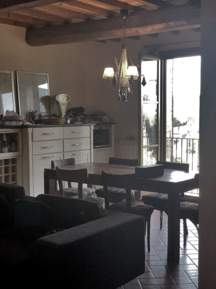 Exemple d'une petite salle à manger ouverte sur le salon méditerranéenne avec un mur beige, tomettes au sol, aucune cheminée, un sol marron et poutres apparentes.