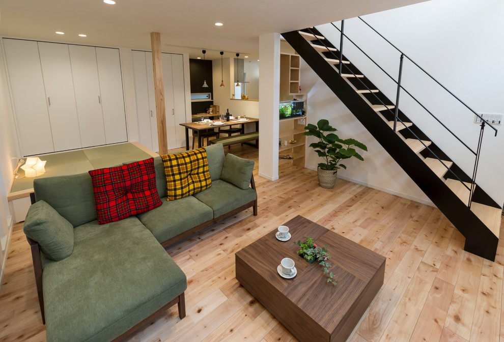 Mid-sized modern open concept living room in Osaka with white walls, light hardwood floors and brown floor.