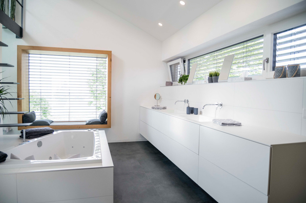 Photo of a mid-sized contemporary bathroom in Munich with white cabinets, white tile, a drop-in sink, solid surface benchtops, black floor, white benchtops, a double vanity and a built-in vanity.