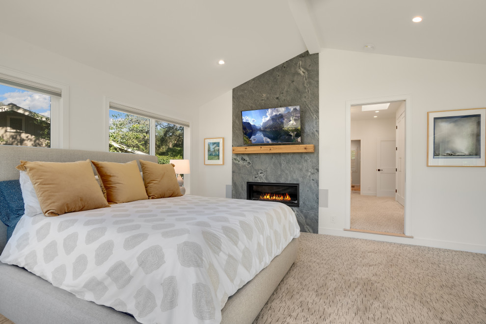 Geräumiges Hauptschlafzimmer mit weißer Wandfarbe, Teppichboden, gefliester Kaminumrandung, buntem Boden und gewölbter Decke in San Francisco