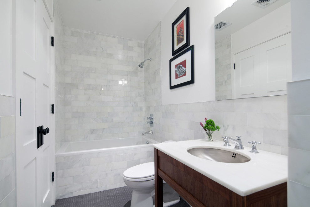 Example of a mid-sized trendy master multicolored tile and stone tile ceramic tile alcove bathtub design in New York with recessed-panel cabinets, a two-piece toilet, white walls, an undermount sink and marble countertops