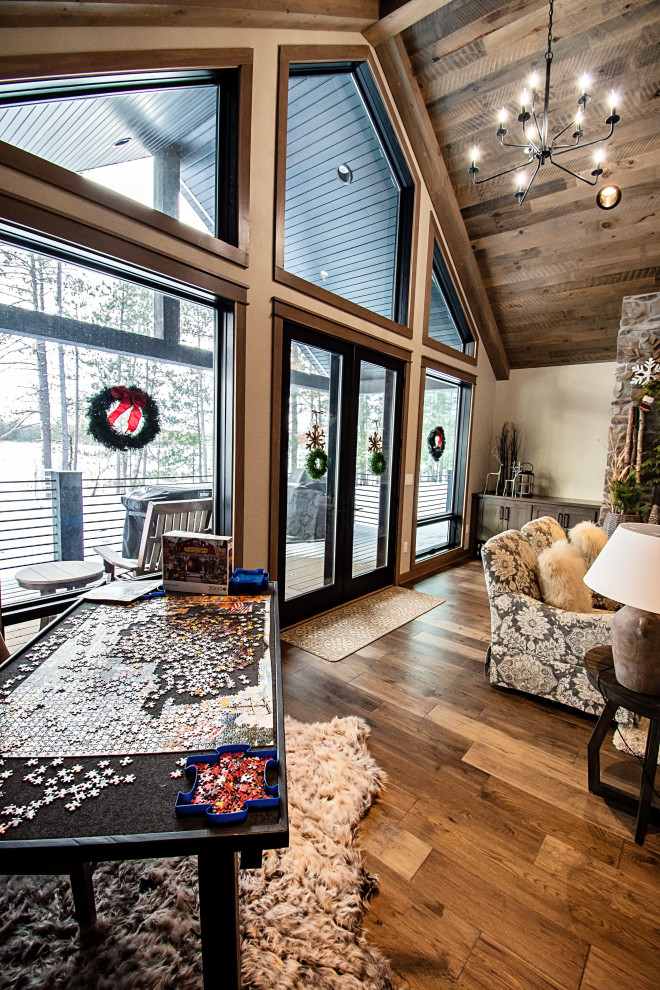 Living room - large rustic open concept light wood floor, multicolored floor, vaulted ceiling and wood wall living room idea with a standard fireplace and a stacked stone fireplace
