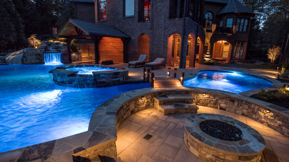 Large traditional back custom shaped natural swimming pool in Atlanta with with pool landscaping.