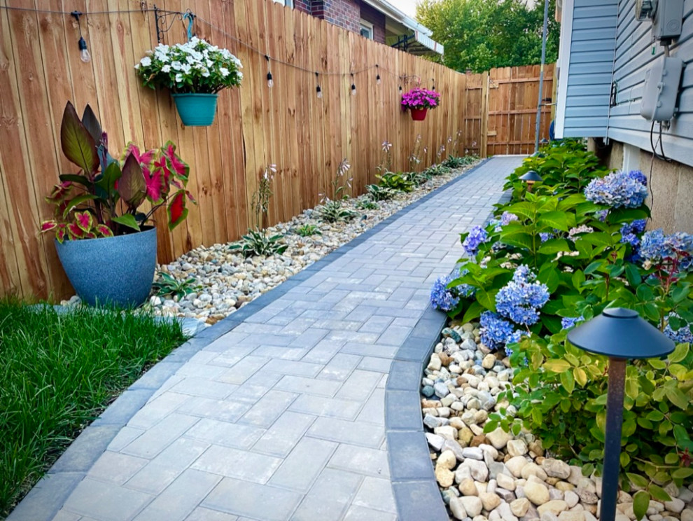 Traditional partial sun garden in Columbus with a pathway, brick paving and a wood fence.