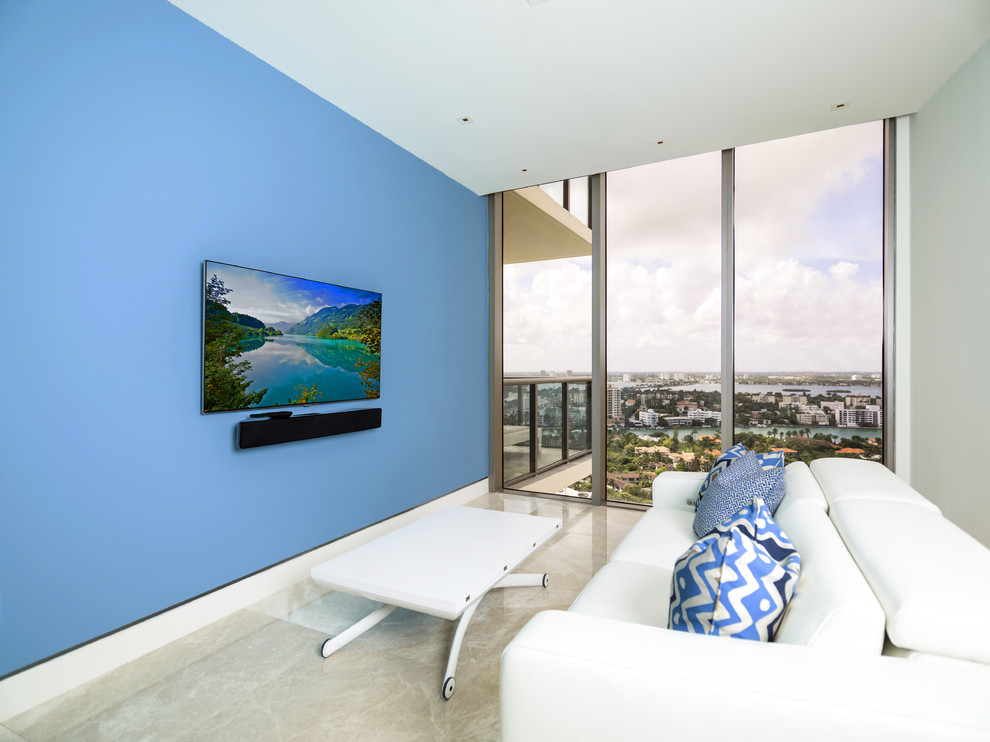 This is an example of a mid-sized contemporary formal enclosed living room in Miami with blue walls, limestone floors, no fireplace and a wall-mounted tv.